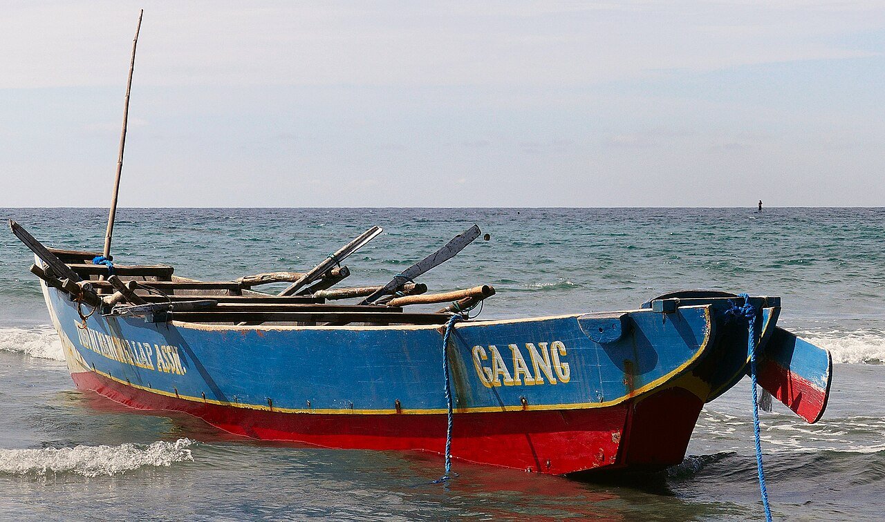 A blue fishing boat on the shore in the Philippines