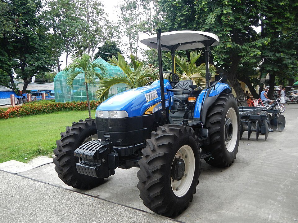 An agricultural tractor with a disc attachment in Camiling, Tarlac